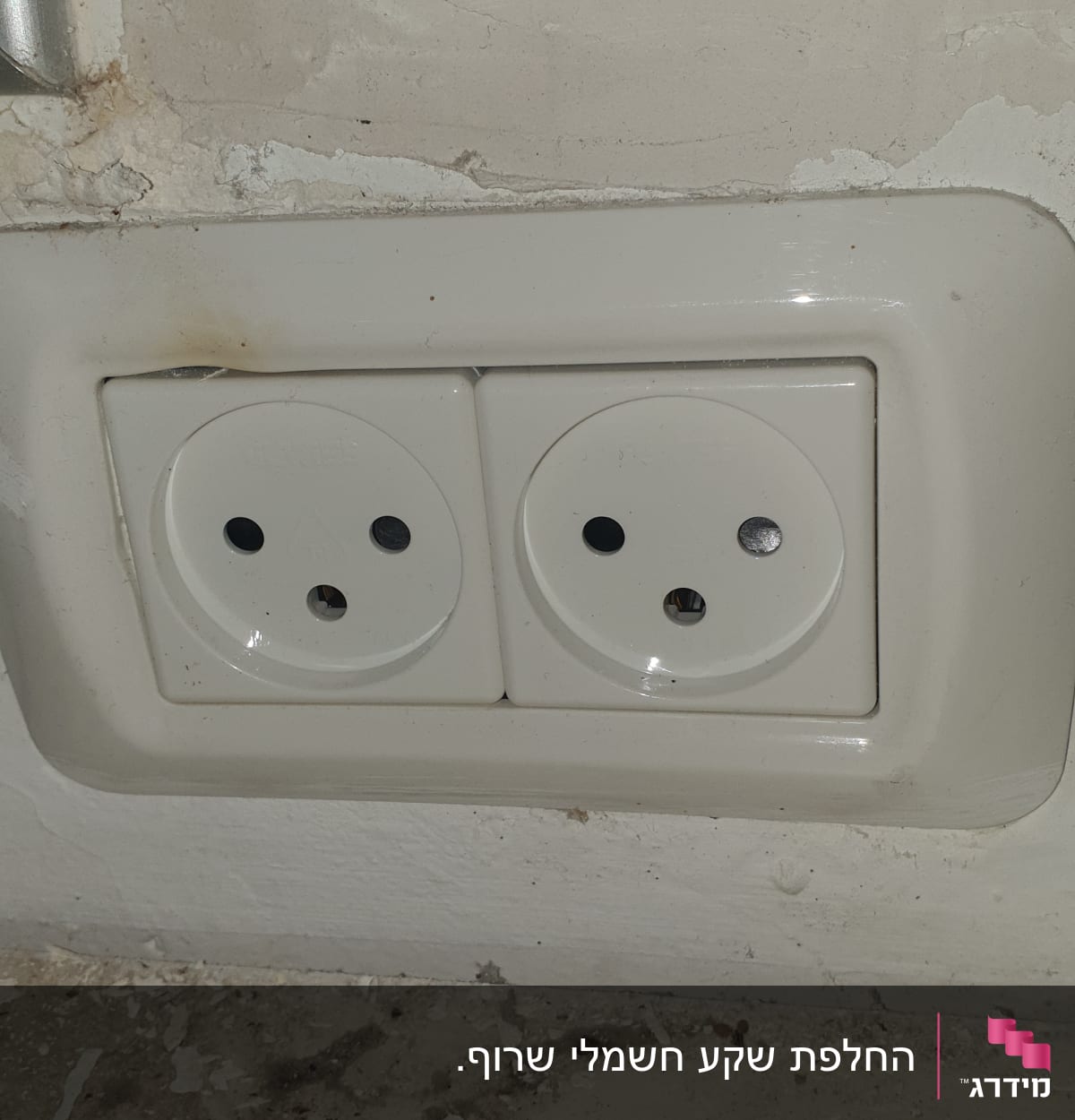 שקע חשמל כפול בקיר עם סימני לכלוך